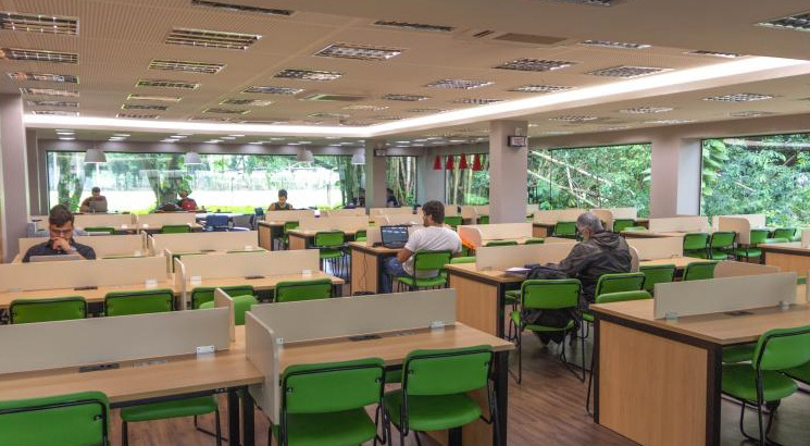 imagem interna de pessoas sentadas na biblioteca da UVA localizada no campus barra
