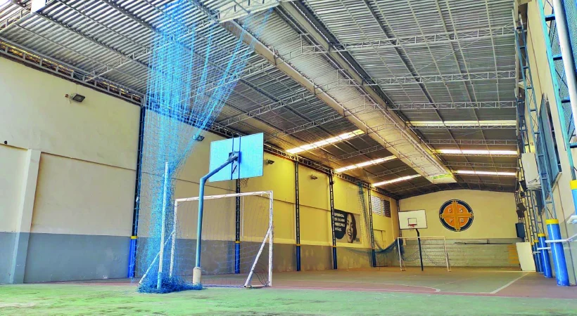 Foto da quadra poliesportiva do Campus Barra da UVA com rede de basquete, gol e rede